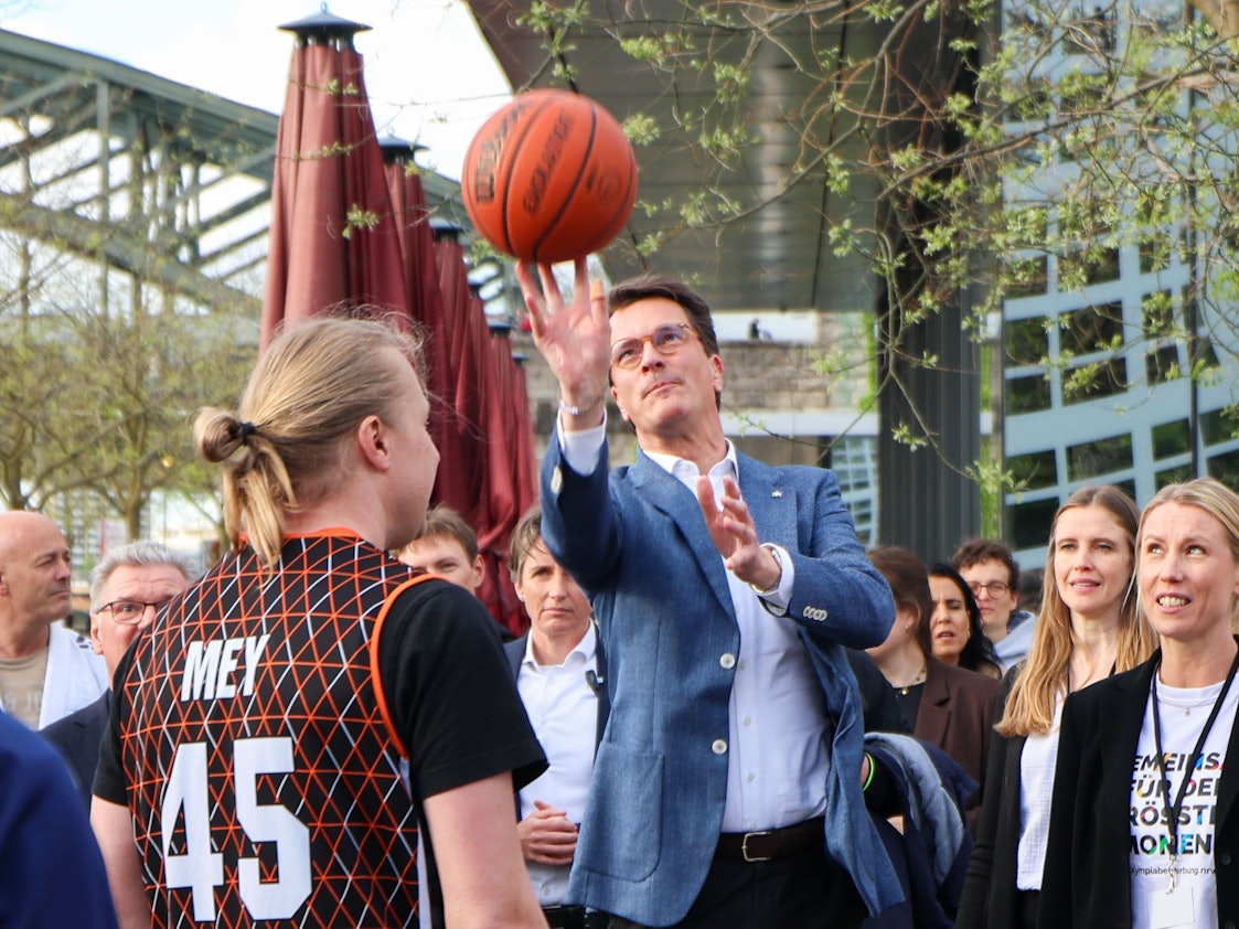 Hendrik Wüst (CDU), Ministerpräsident des Landes NRW, spielt mit einigen Sportlern Basketball auf der Rheinpromenade in Deutz. An diesem Sonntag entscheidet sich, ob die Bevölkerung in Nordrhein-Westfalen Teil der Bewerbung „KölnRheinRuhr“ für die Olympischen und Paralympischen Sommerspiele in den Jahren 2036, 2040 oder 2044 werden will.