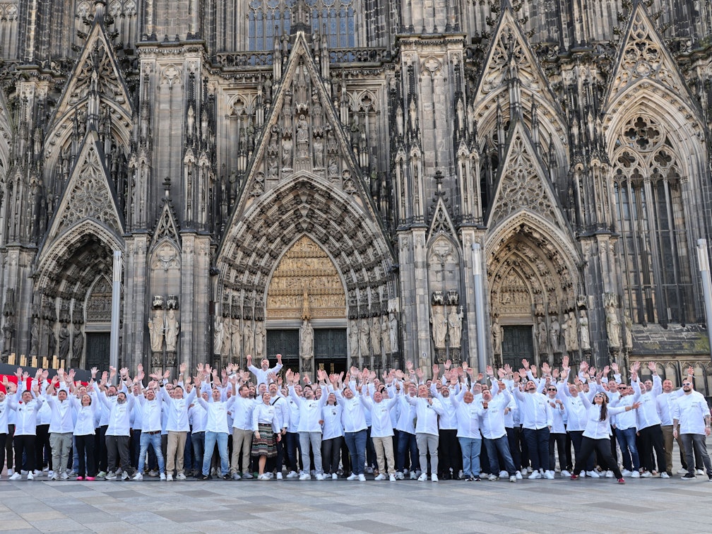 Köchinnen und Köche posieren vor dem Kölner Dom.