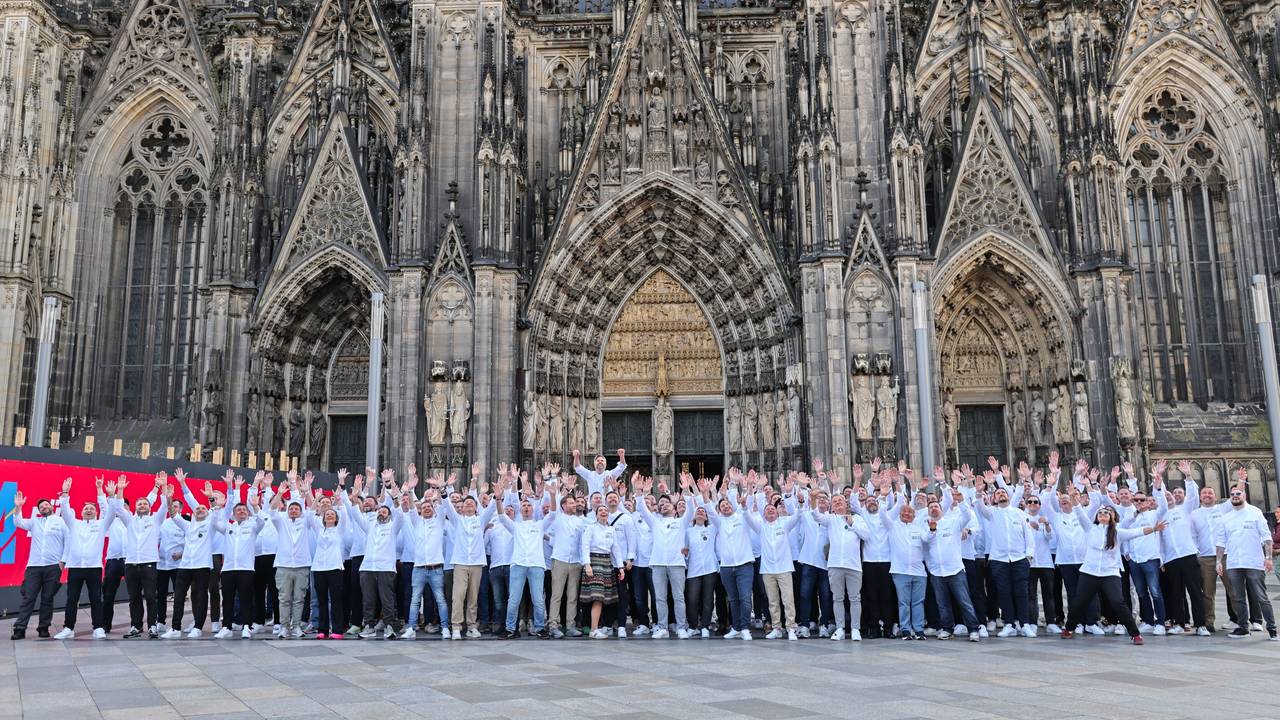 Köchinnen und Köche posieren vor dem Kölner Dom.