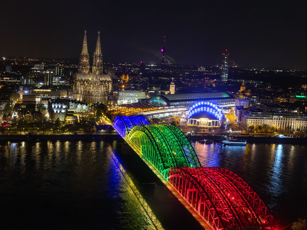 Die Bögen der Hohenzollernbrücke sind am Abend der Olympia-Abstimmung bunt beleuchtet wie Olympiaringe.