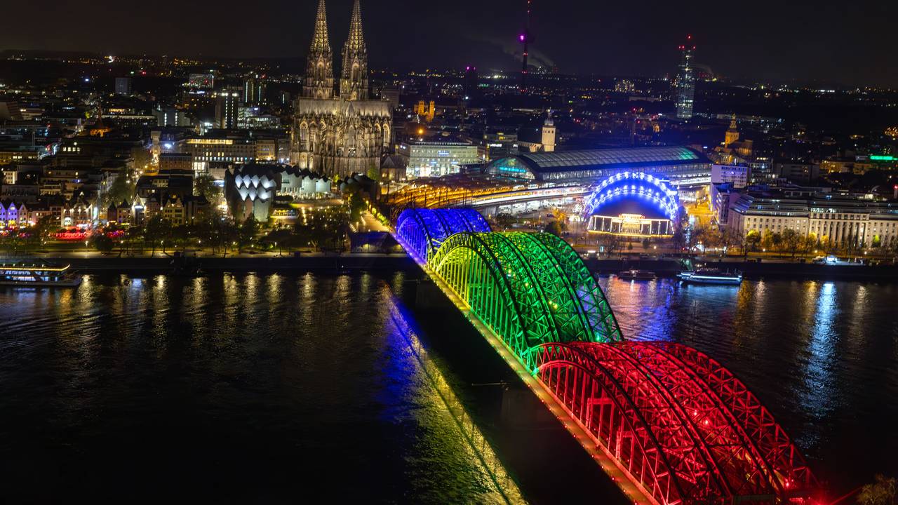 Die Bögen der Hohenzollernbrücke sind am Abend der Olympia-Abstimmung bunt beleuchtet wie Olympiaringe.