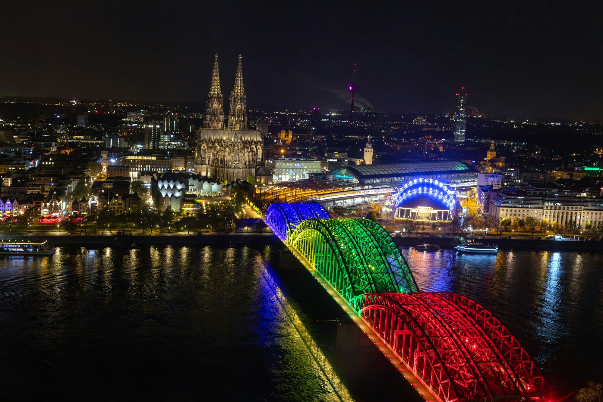 Die Bögen der Hohenzollernbrücke sind am Abend der Olympia-Abstimmung bunt beleuchtet wie Olympiaringe.