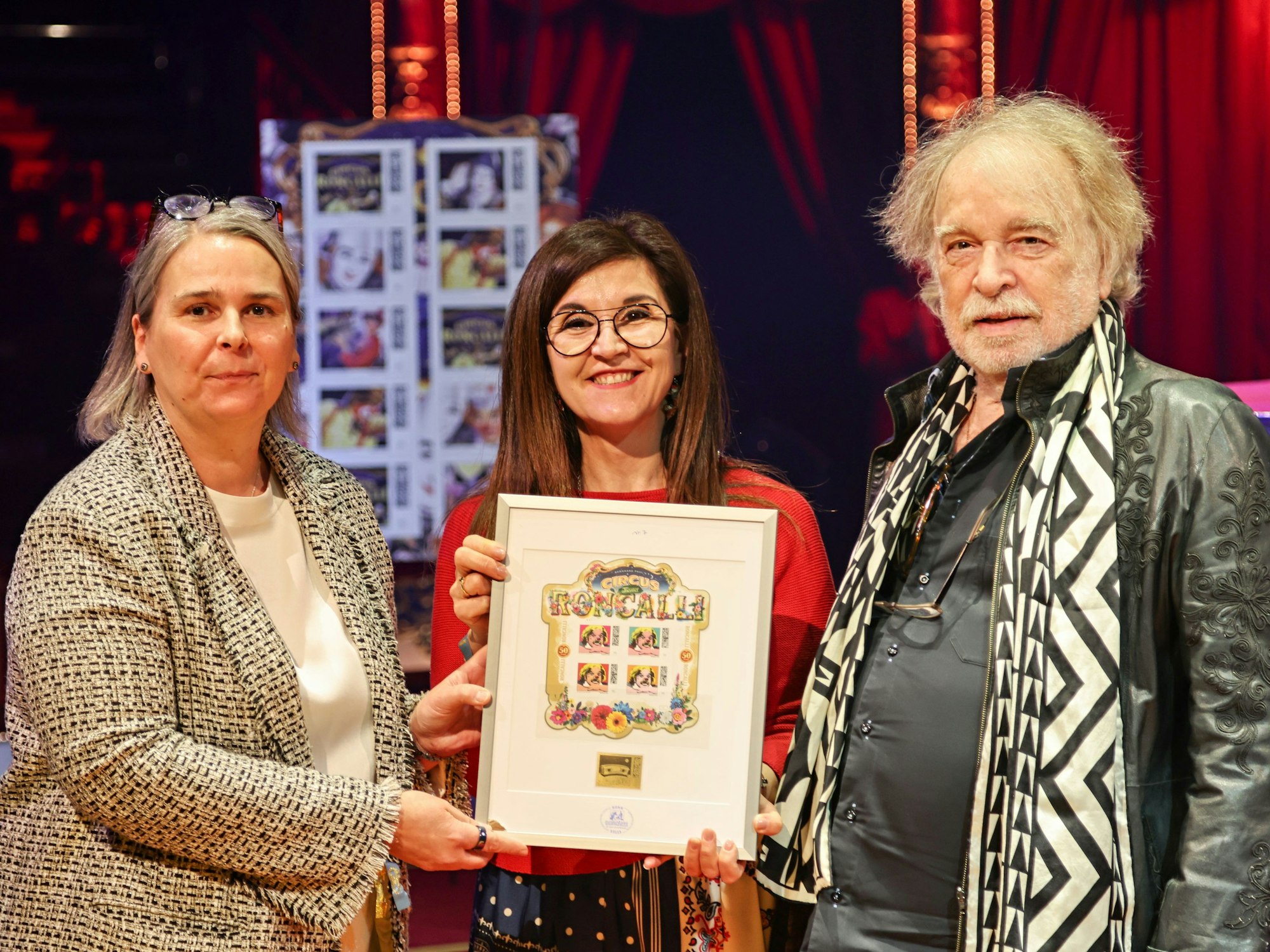 Nikola Hagleitner, Teresa De Bellis-Olinger und Bernhard Paul mit einer Briefmarke.