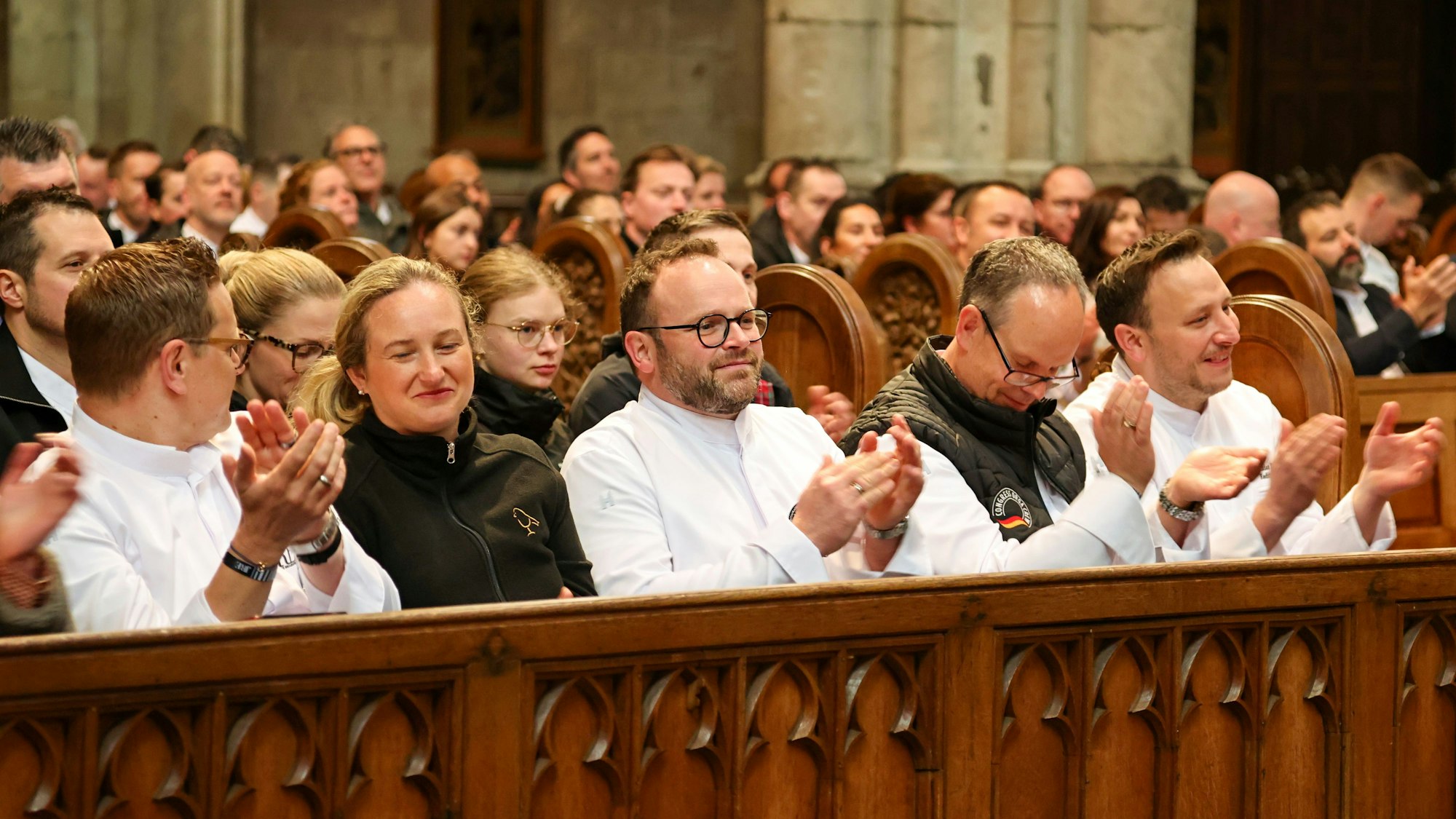 Oliver Röder sitzt im Kölner Dom und klatscht zur Musik der Höhner.