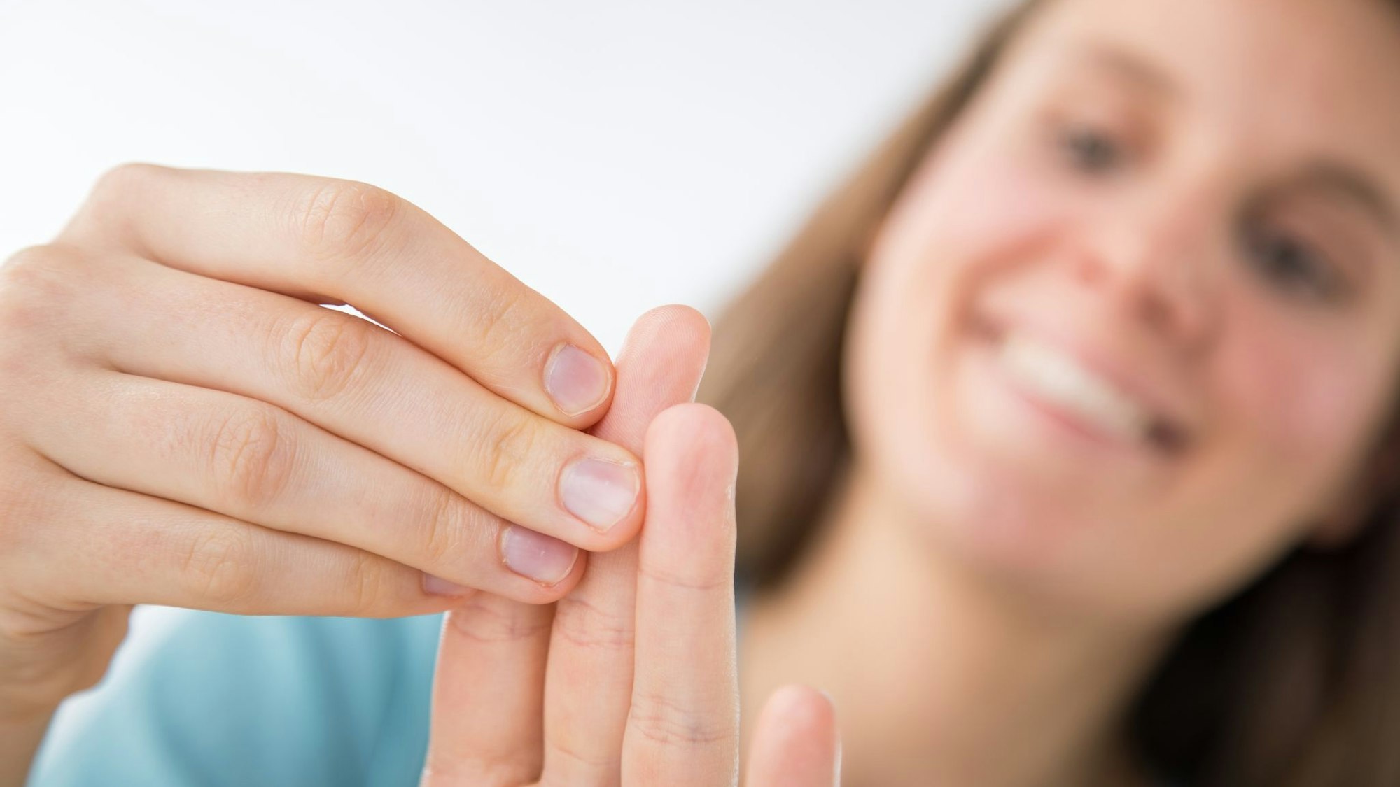 Eine Frau betrachtet ihre Fingernägel