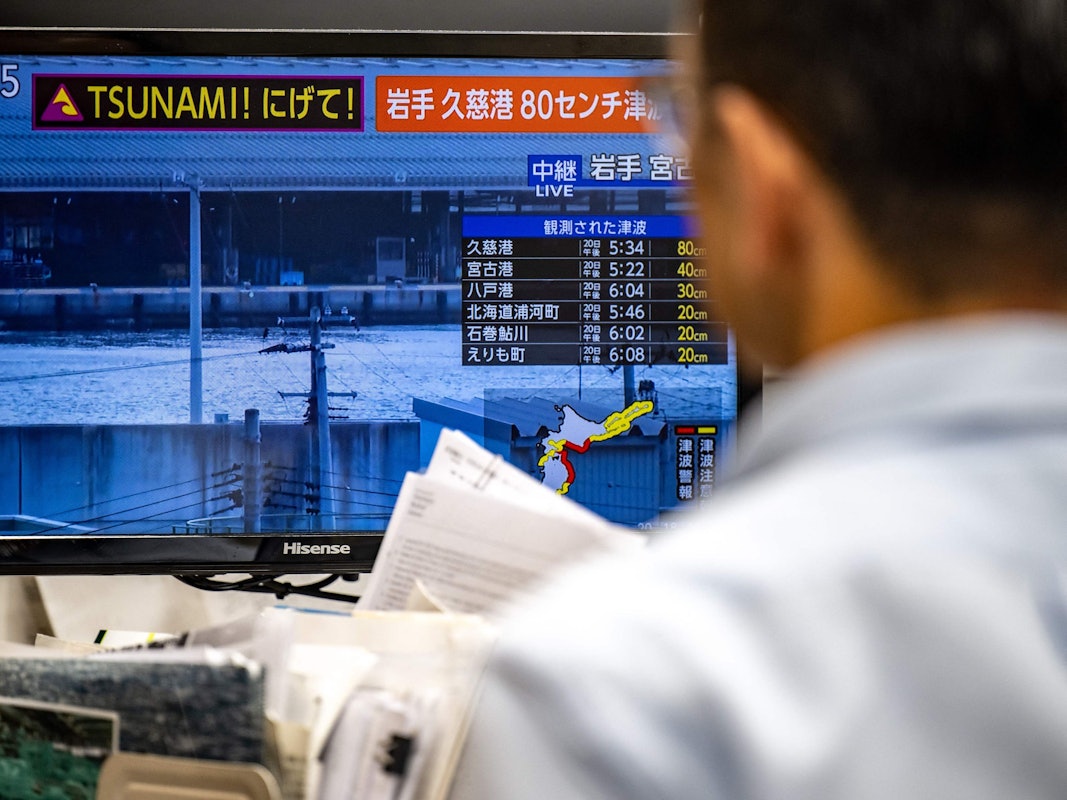 Dieses Foto zeigt eine Warnmeldung auf einem Bildschirm, die aus einer Live-Übertragung stammt und eine Tsunami-Warnung nach einem Erdbeben im Norden Japans anzeigt.