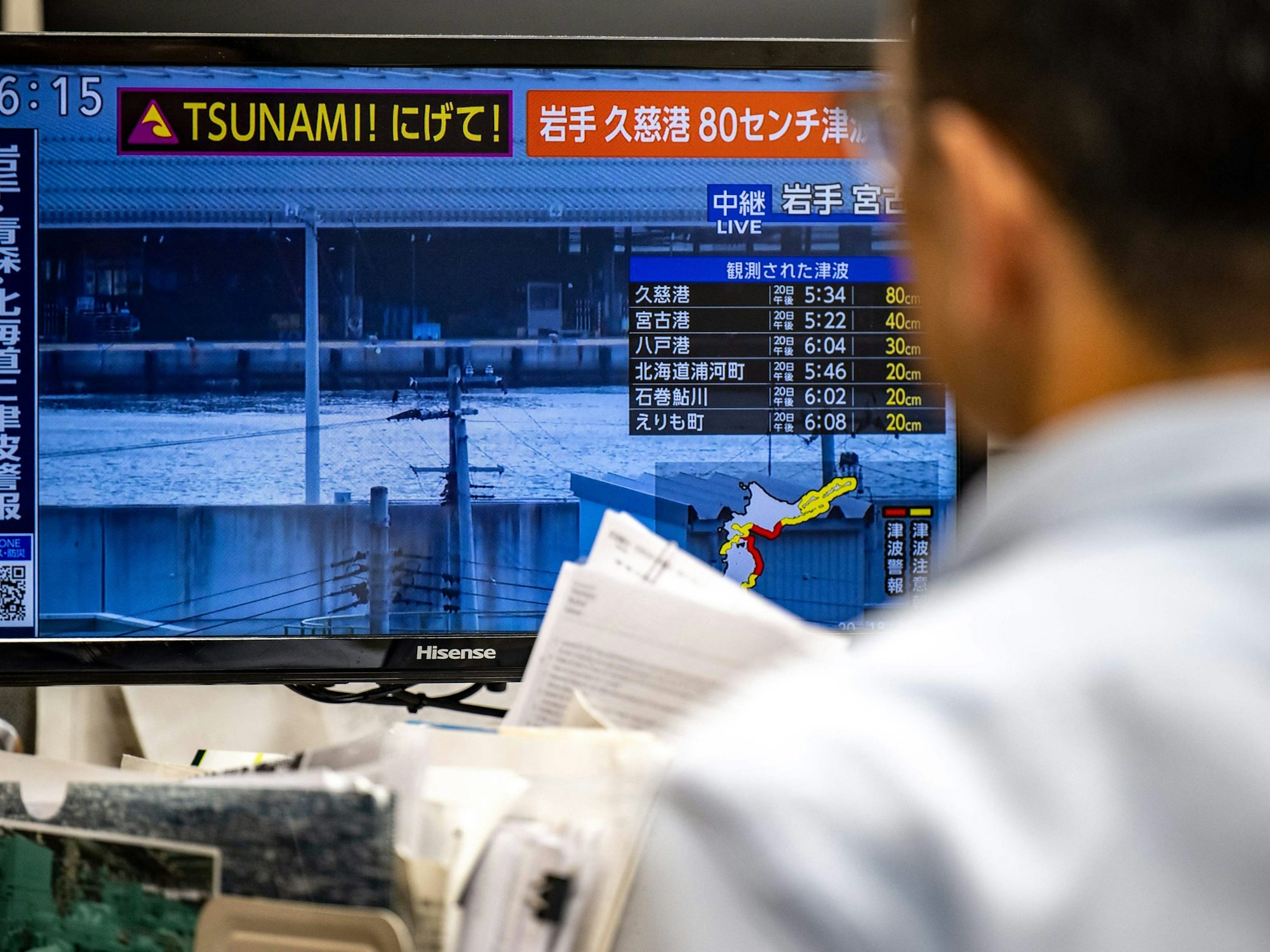Dieses Foto zeigt eine Warnmeldung auf einem Bildschirm, die aus einer Live-Übertragung stammt und eine Tsunami-Warnung nach einem Erdbeben im Norden Japans anzeigt.