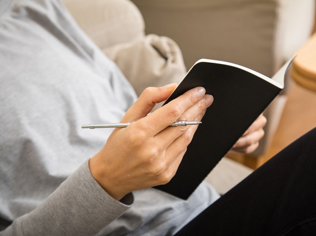 Eine Frau schreibt in ein Heft