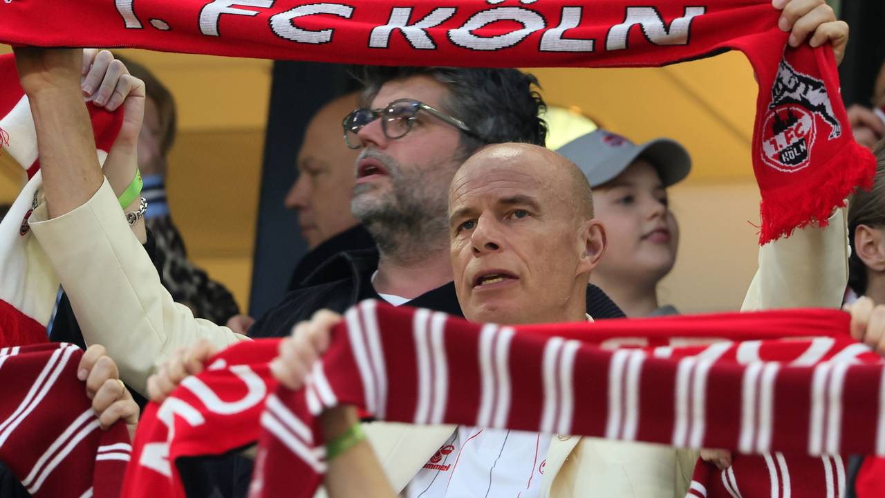 Jörn Stobbe hält bei der Hymne des 1. FC Köln seinen Schal hoch.