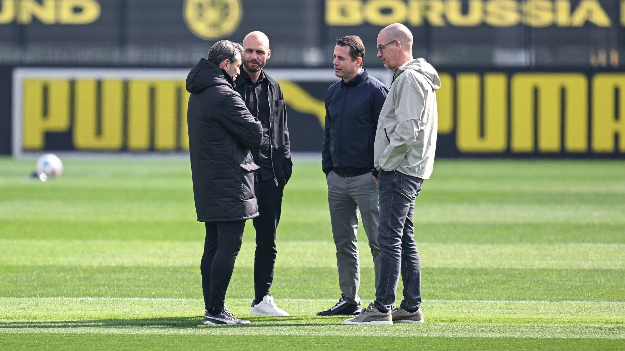 Sportdirektor Ole Book (2.v.l.), Trainer Niko Kovac (l.), Geschäftsführer Sport Lars Ricken und Geschäftsführer Carsten Cramer (r.) unterhalten sich auf dem Trainingsplatz miteinander.