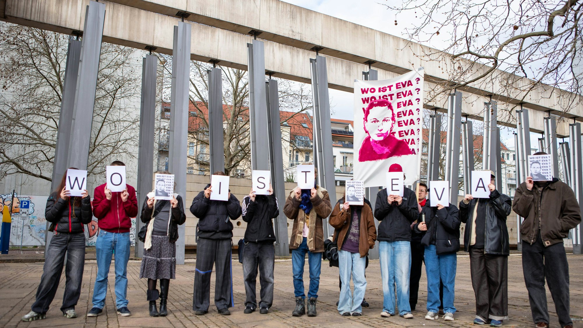 Menschen zeigen Schilder, fragen nach Eva Michelmann