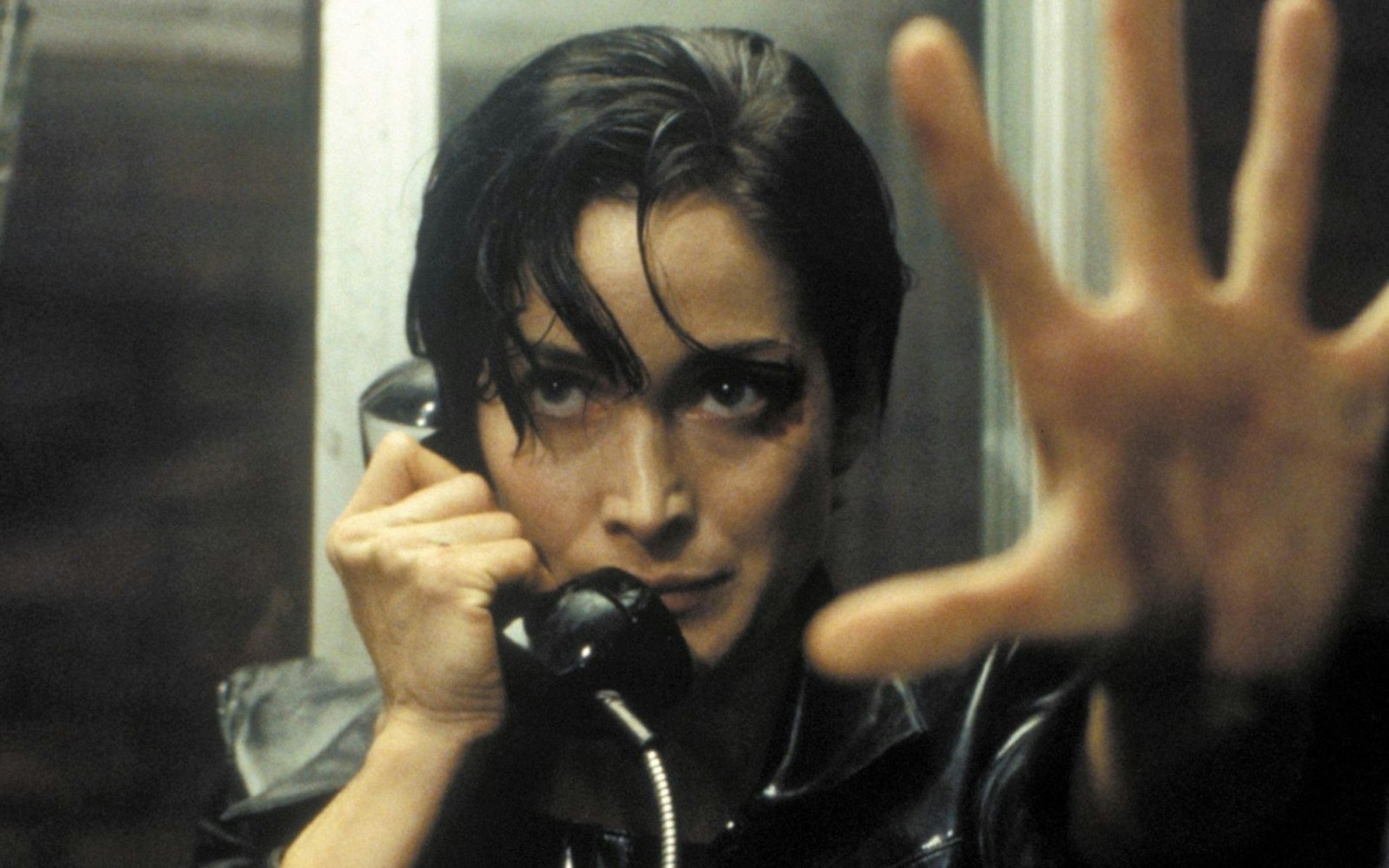 Trinity (Carrie-Anne Moss) nimmt den Ausgang aus der Matrix: eine öffentliche Telefonzelle. (Bild: RTL / 1999 Warner Bros. Entertainment Inc. )