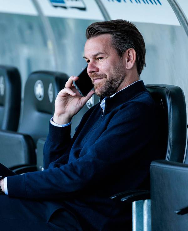 Thomas Kessler telefoniert vor einem FC-Spiel im Stadion.