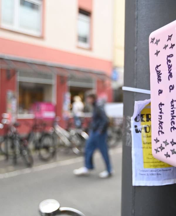 Eine bunte, mit Stickern beklebte Box hängt an einem Pfahl.