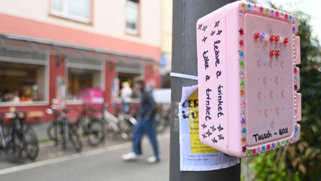Eine bunte, mit Stickern beklebte Box hängt an einem Pfahl.