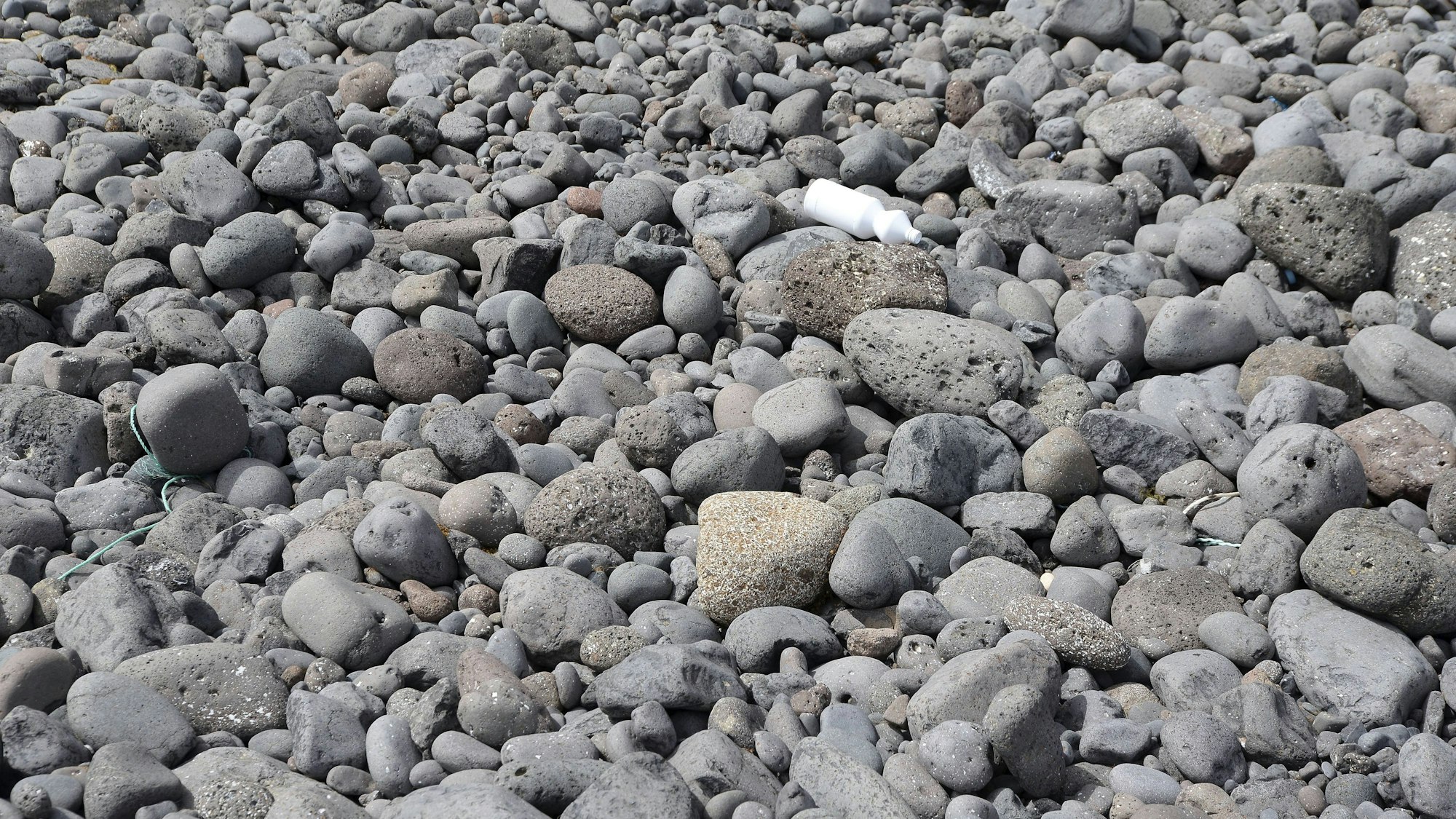 Steine und Müll am Strand