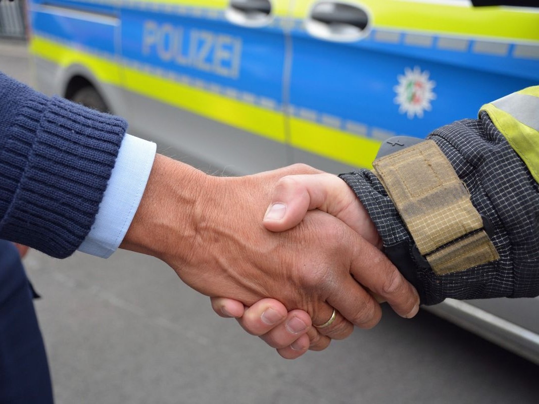 Ein ausgebrannter Müllcontainer steht an einer Hauswand.