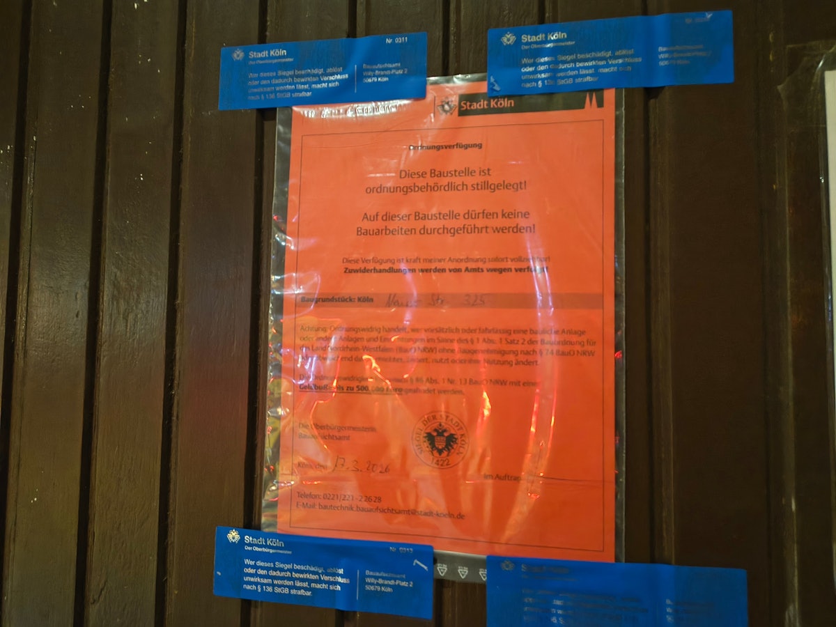 Dieser rote Zettel hängt an der Tür – die Baustelle im Hinterhof auf der Neusser Straße wurde von der Stadt stillgelegt.