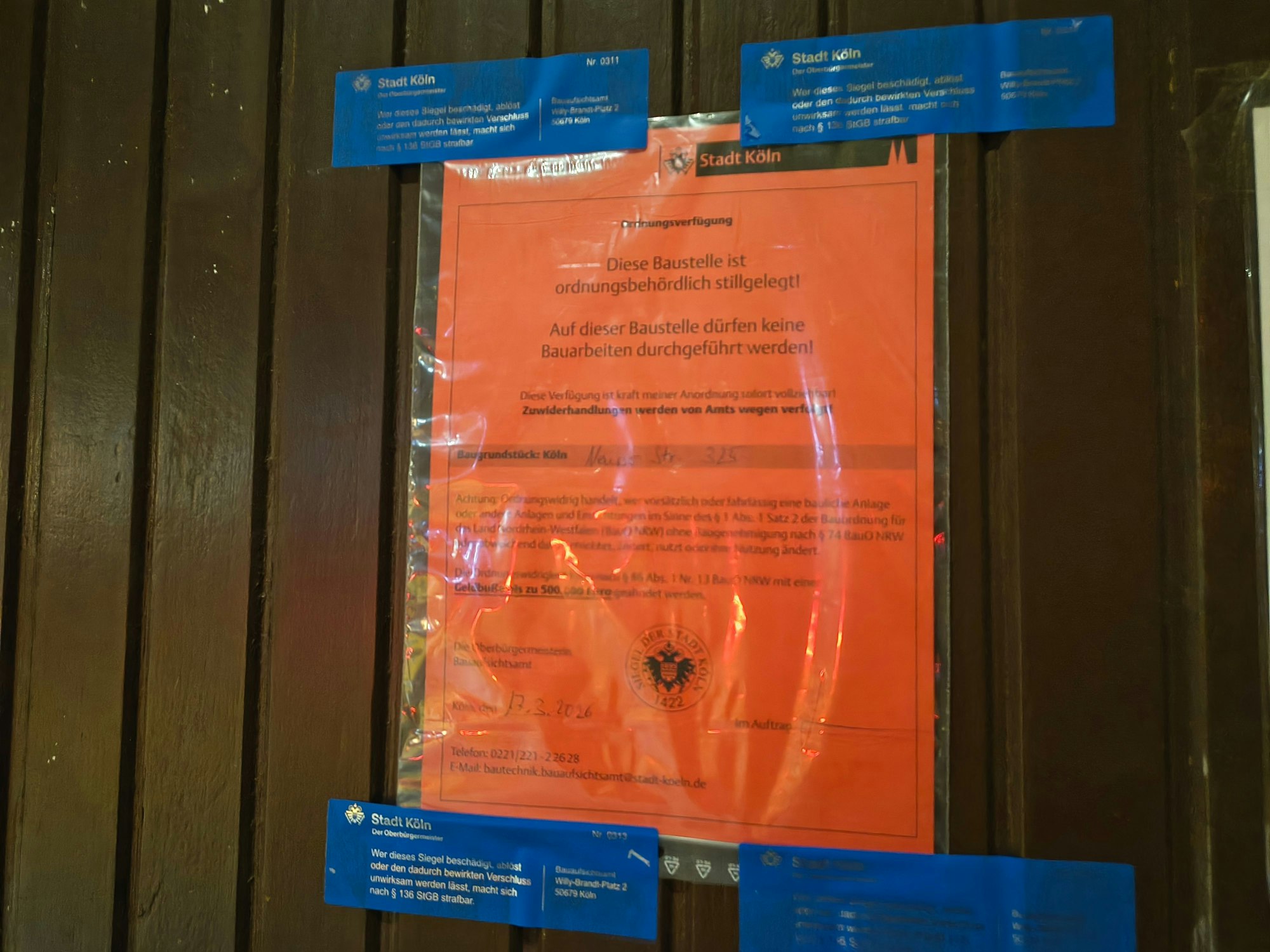 Dieser rote Zettel hängt an der Tür – die Baustelle im Hinterhof auf der Neusser Straße wurde von der Stadt stillgelegt.