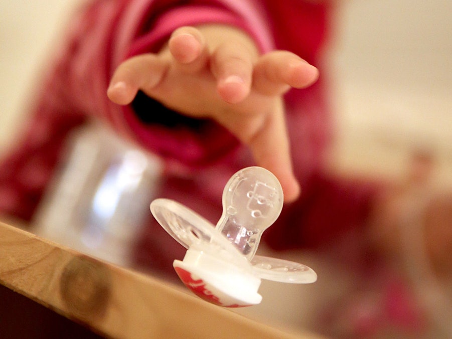 Kleinkind greift nach einem Schnuller