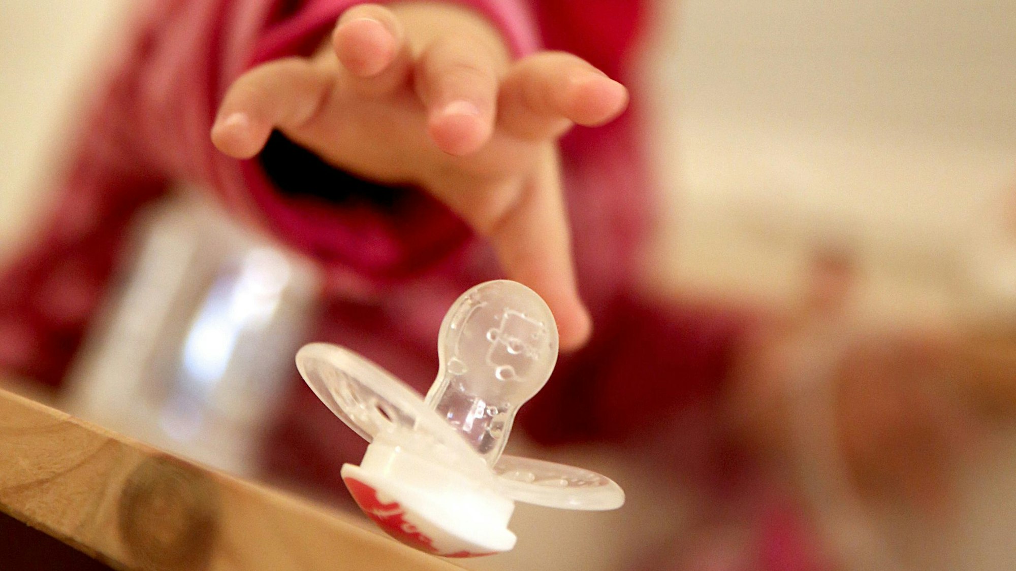 Kleinkind greift nach einem Schnuller