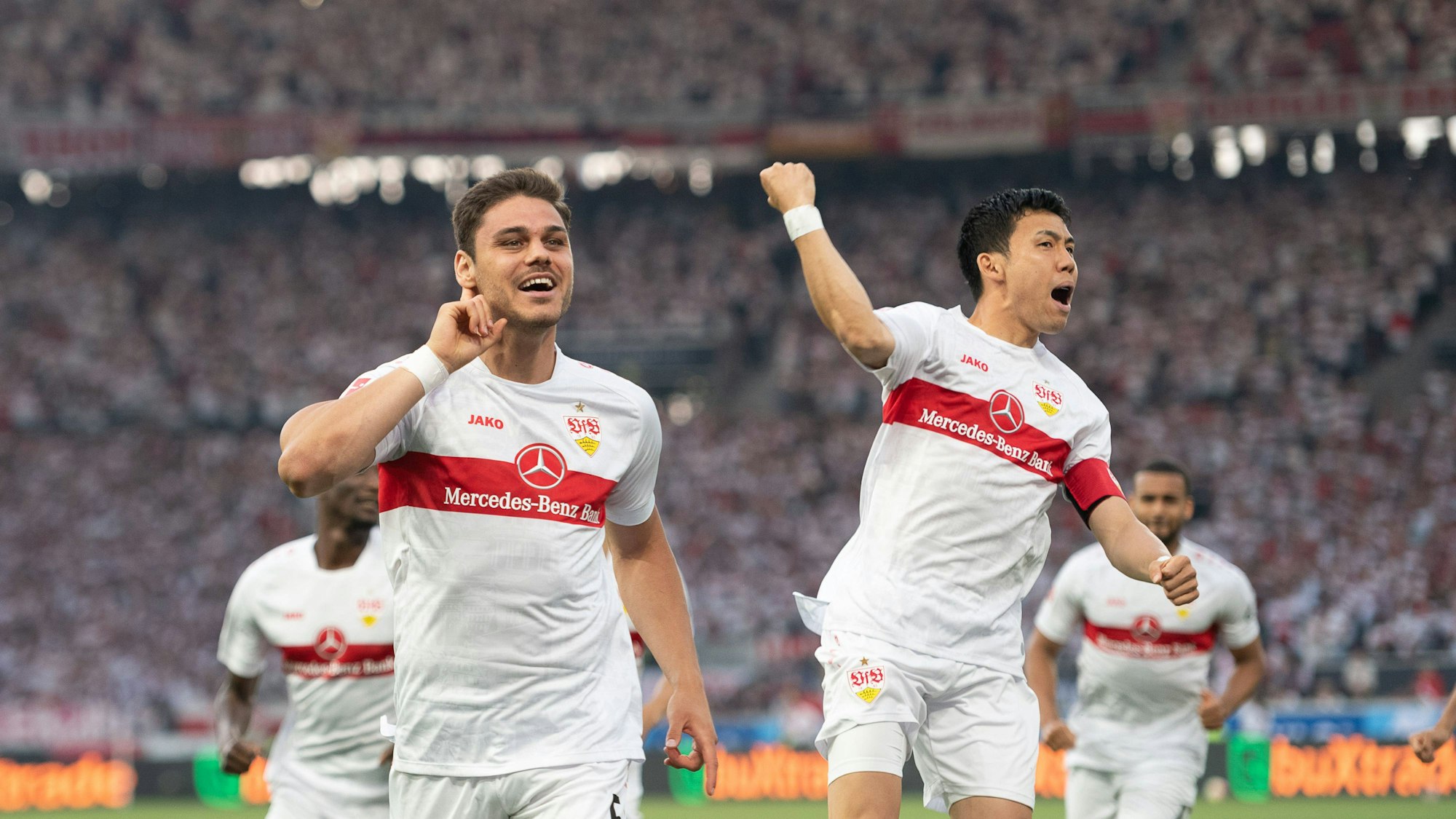 Konstantinos Mavropanos (l.) und Wataru Endo jubeln nach einem Treffer.