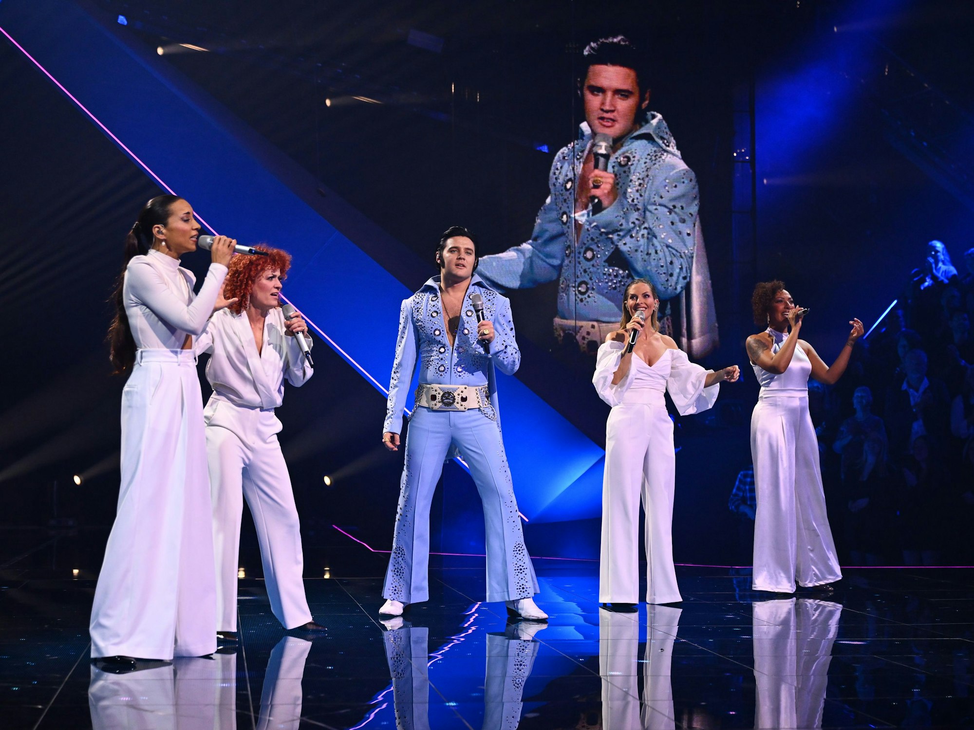 Die No Angels singen zusammen mit Elvis Presley auf der Bühne.