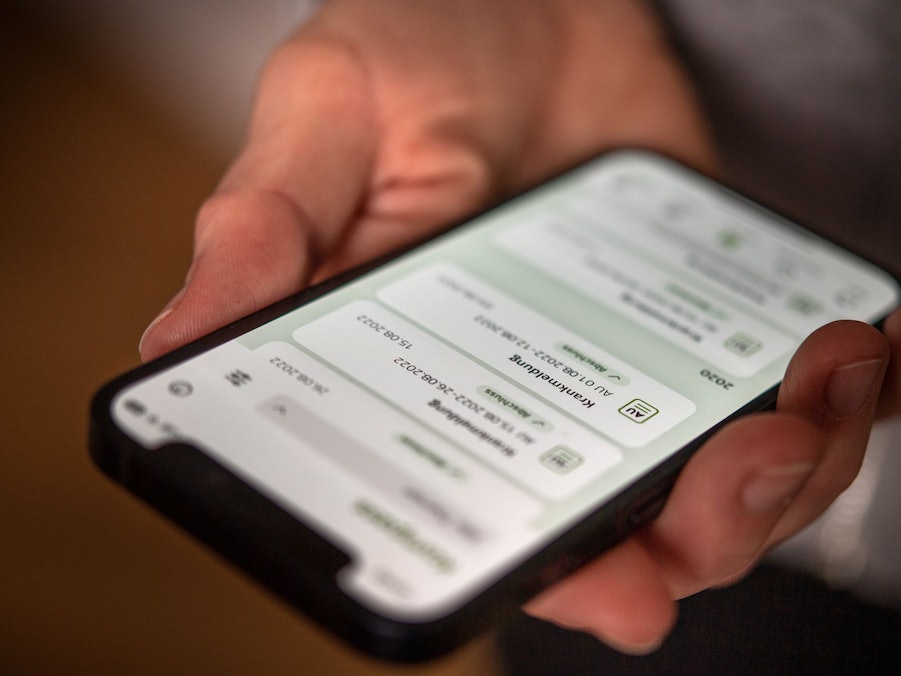 Eine elektronische AU ist auf dem Display eines Handys zu sehen