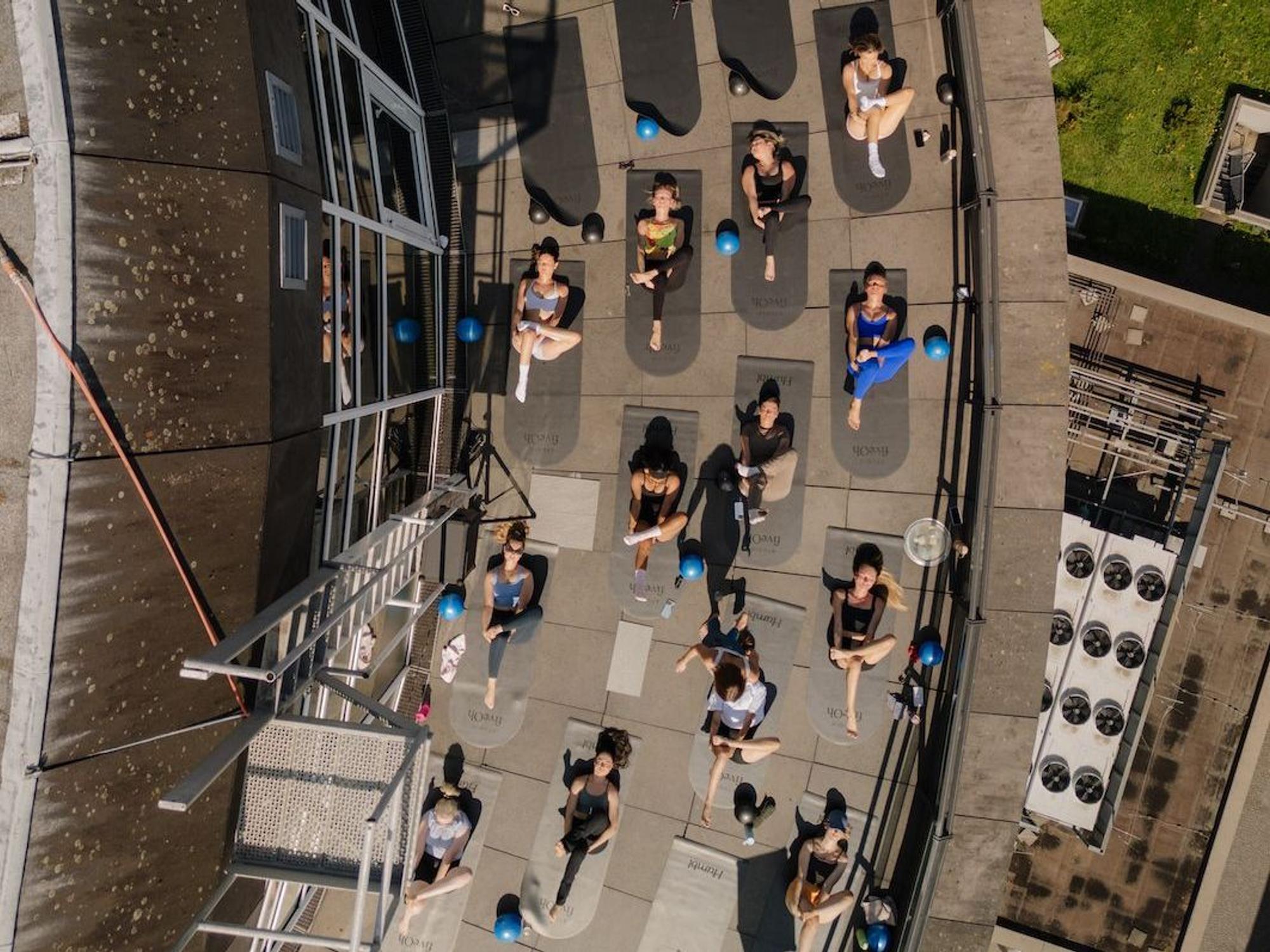 Gäste machen Pilates auf der Dachterrasse.