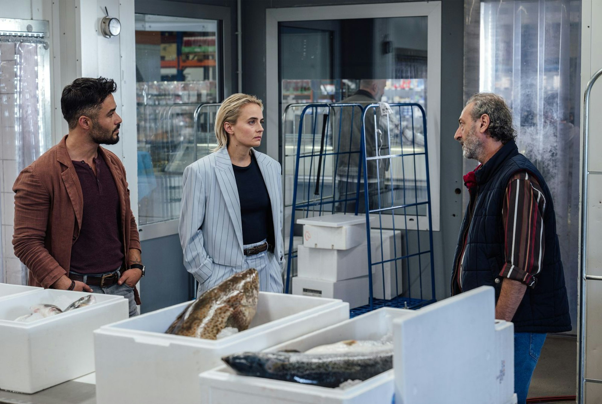 Tayfun (Aram Arami, links) bekommt aus dem Fischgroßhändler Massimo (Claudio Caiolo), bei dem der ermordete Enzo jobbte, mehr heraus als seine ehemalige Kollegin, Kriminalhauptkommissarin Elisa Santori (Olga von Luckwald). (Bild: SR/Manuela Meyer)