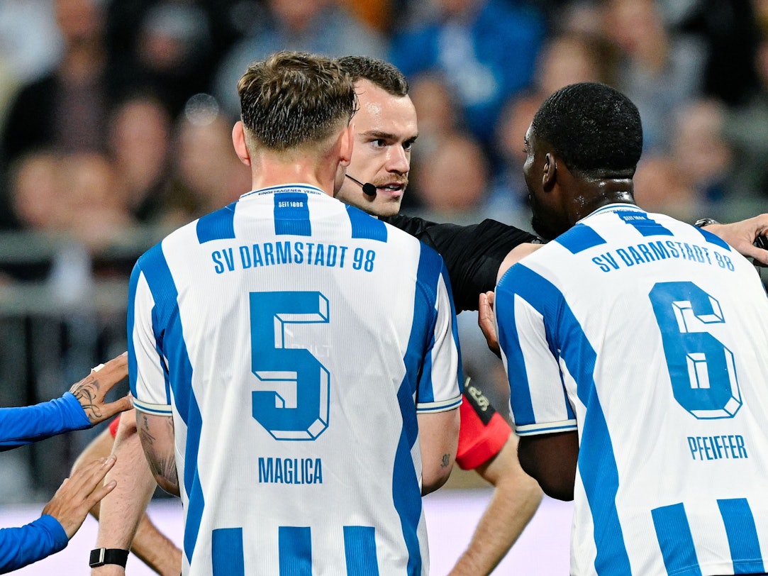 Die Spieler von Darmstadt 98 diskutieren mit Schiedsrichter Richard Hempel.