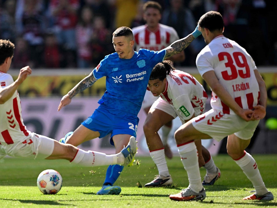Derby zwischen dem 1. FC Köln und Bayer Leverkusen: Alejandro Grimaldo (Mitte, Leverkusen) schießt, Kölns Eric Martel grätscht.