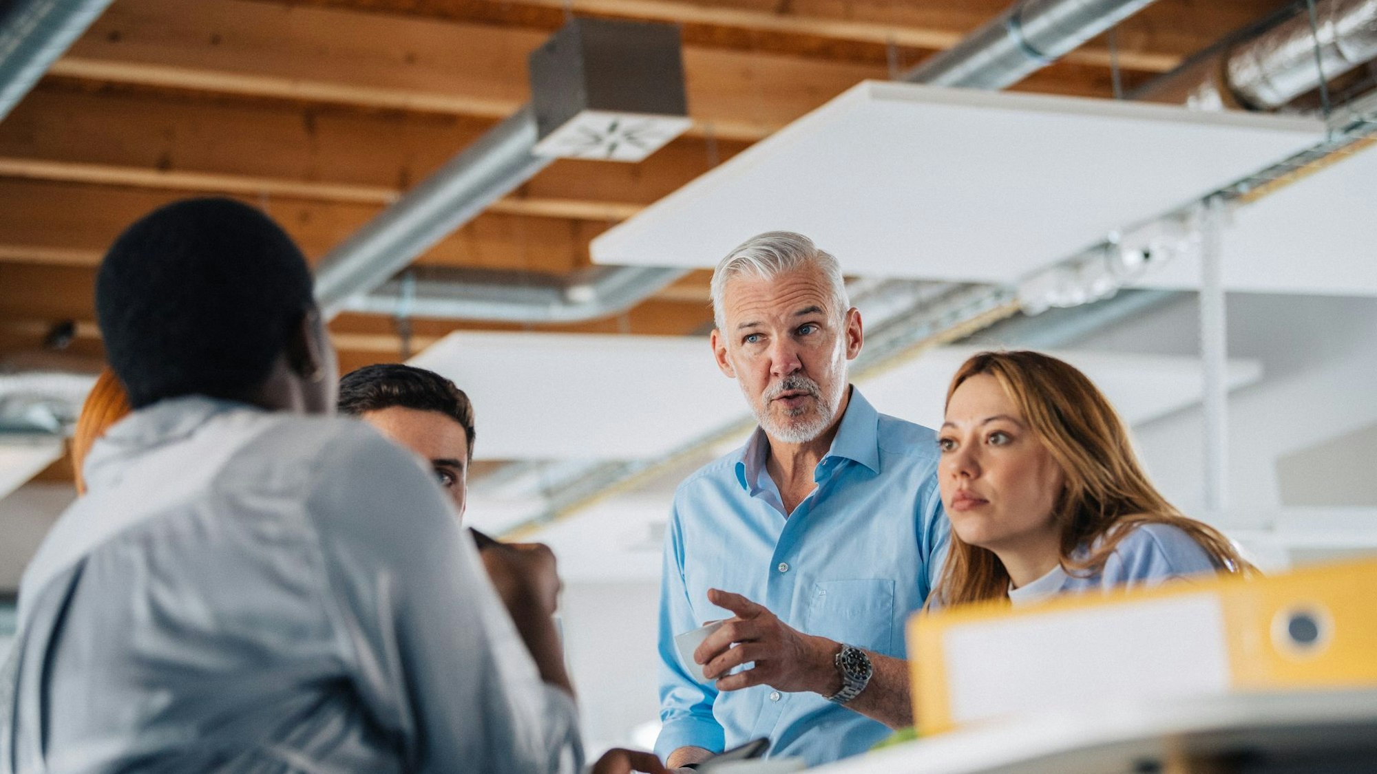 Eine Gruppe Kolleginnen und Kollegen an einem Stehtisch