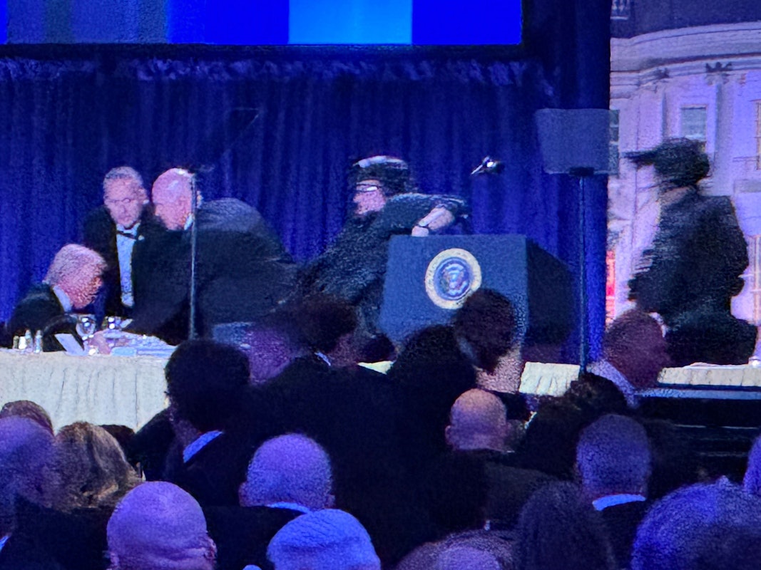 US-Präsident Donald Trump (l) sitzt auf der Bühne, während Agenten des US-Geheimdienstes ihn nach einem Vorfall außerhalb des Ballsaals während des White House Correspondents' Dinner aus dem Ballsaal bringen.