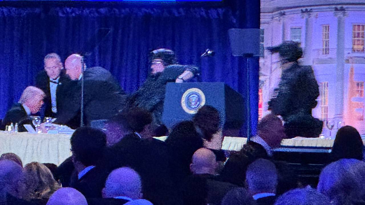 US-Präsident Donald Trump (l) sitzt auf der Bühne, während Agenten des US-Geheimdienstes ihn nach einem Vorfall außerhalb des Ballsaals während des White House Correspondents' Dinner aus dem Ballsaal bringen.