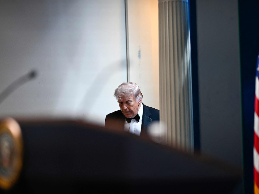 Donald Trump betritt mit gesenktem Haupt den Raum.