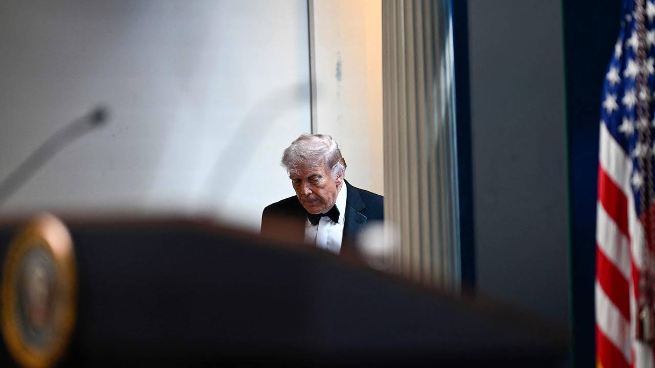 Donald Trump betritt mit gesenktem Haupt den Raum.