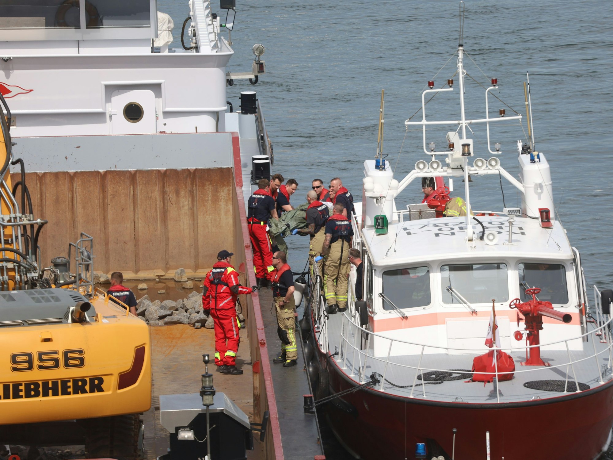 Ein Leichnam wird von einem Schiff auf ein anderes getragen.