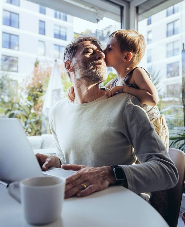 Mann mit Sohn arbeitet im Homeoffice