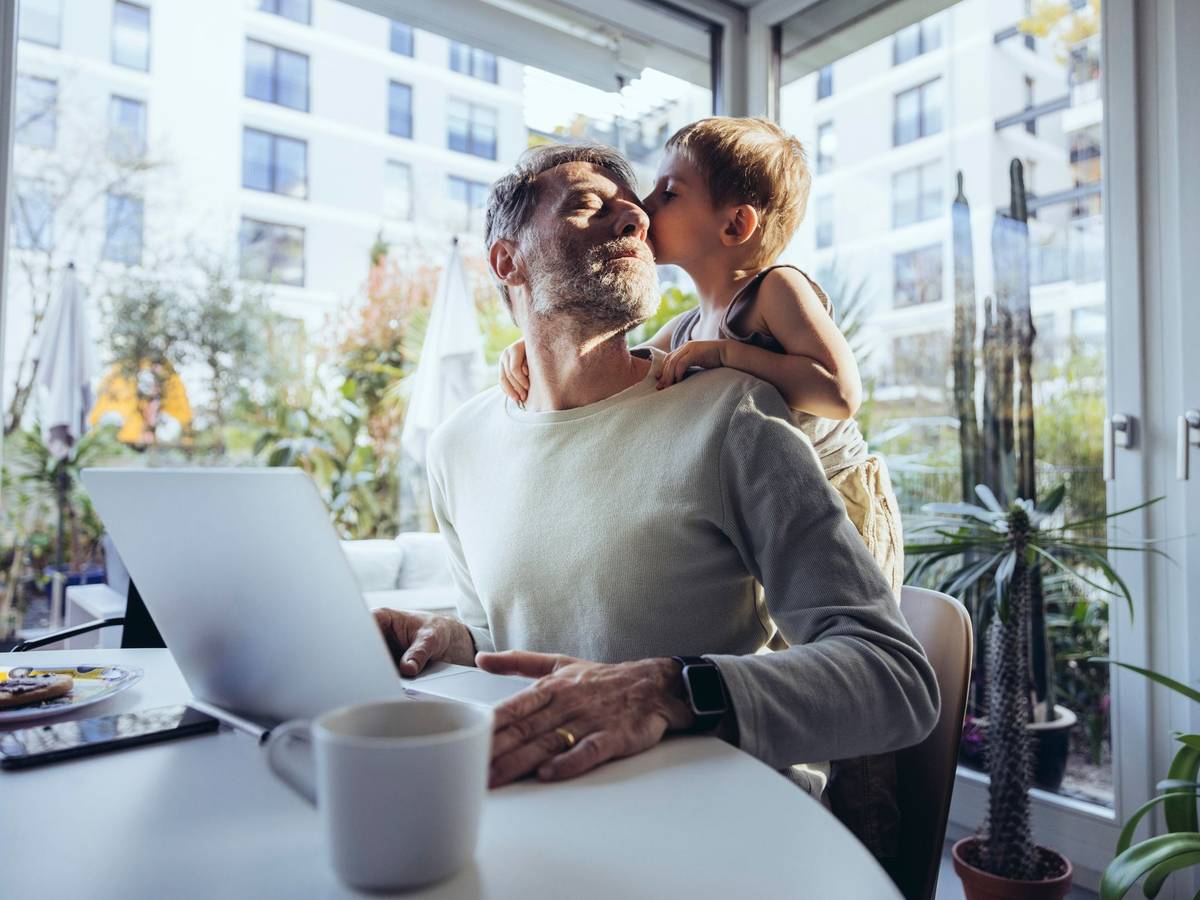 Mann mit Sohn arbeitet im Homeoffice