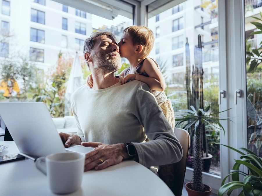 Mann mit Sohn arbeitet im Homeoffice