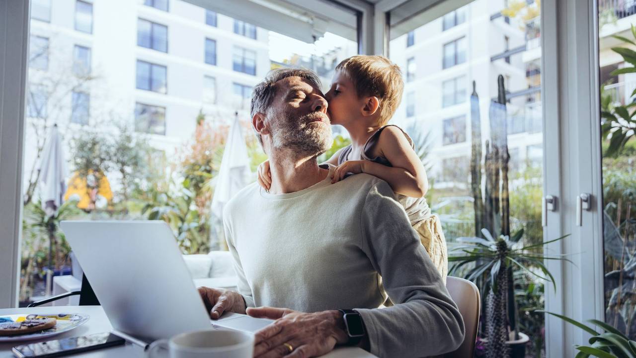 Mann mit Sohn arbeitet im Homeoffice