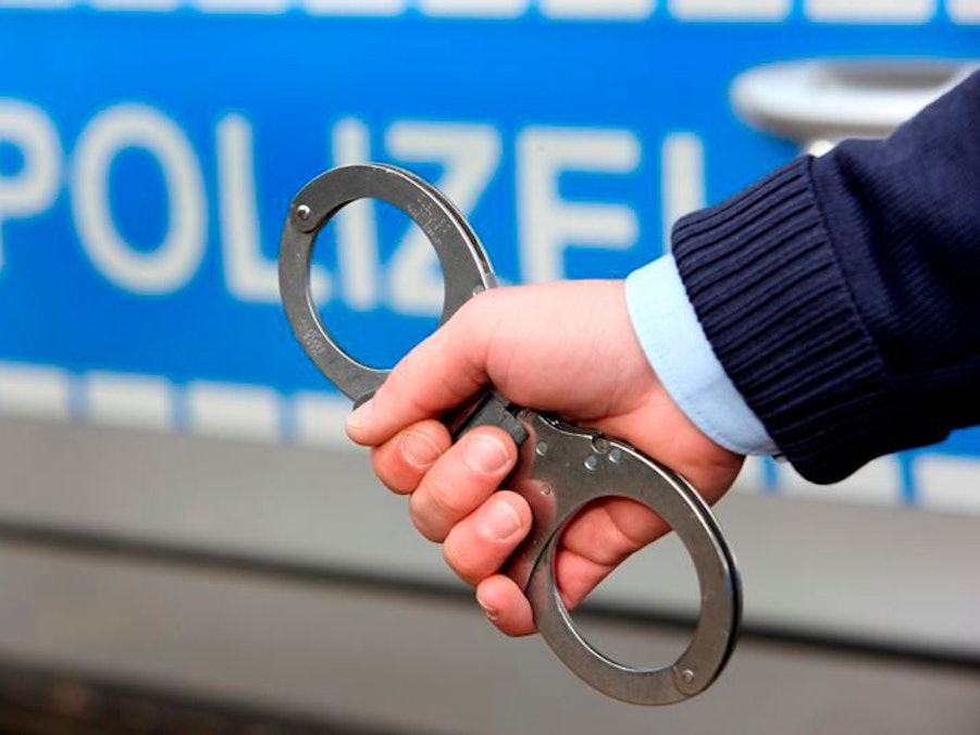 Symbolbild: Handschellen werden einer Person angelegt.