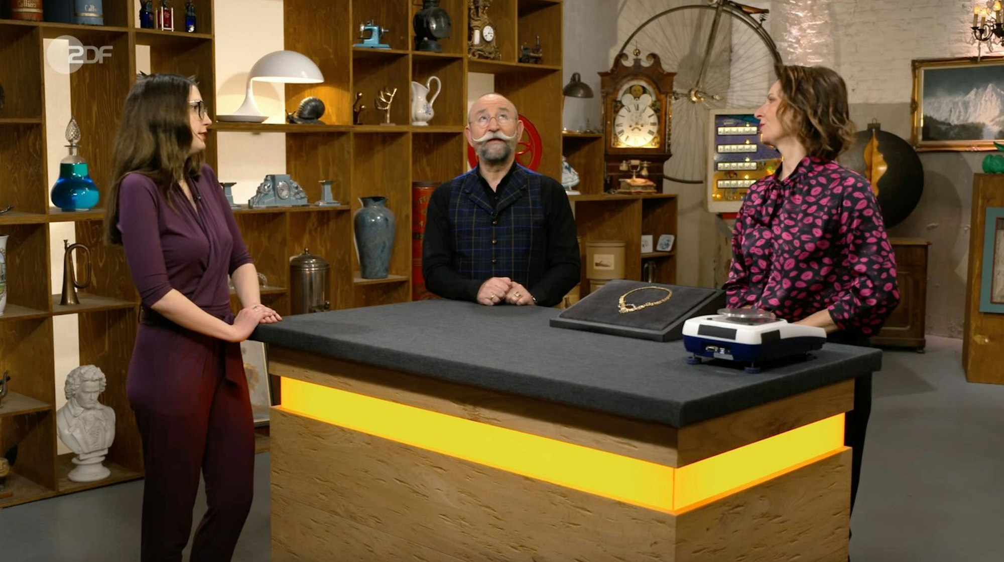 Mit einem begeisterten „Oh, welch ein Geschmeide“ reagierte Horst Lichter in der Montagsausgabe von „Bares für Rares“ (ZDF) auf ein besonderes Collier, das einst als Wertanlage gekauft wurde. Doch die Geschichte dahinter war bewegender: Denn ursprünglich wollte die Mutter der Verkäuferin den Schmuck selbst ins Pulheimer Walzwerk bringen. (Bild: ZDF)