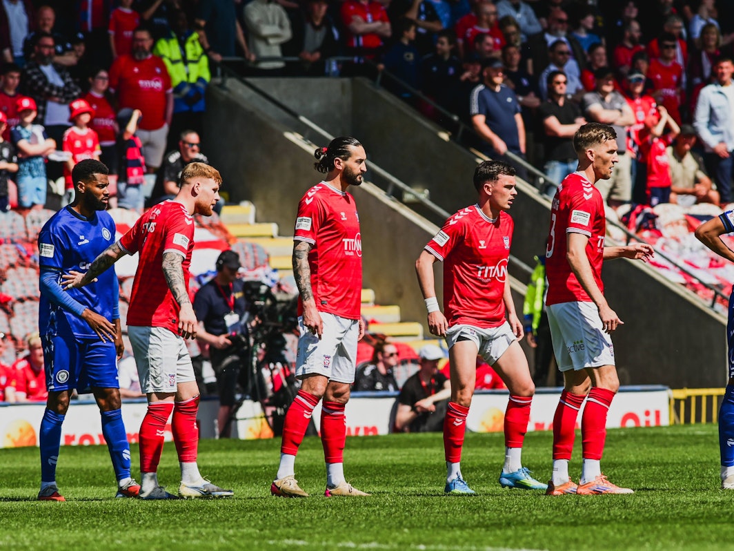 Spieler von York City und AFC Rochdale stehen auf dem Rasen.