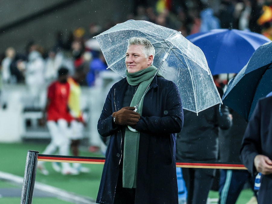 Bastian Schweinsteiger mit Schirm im Regen