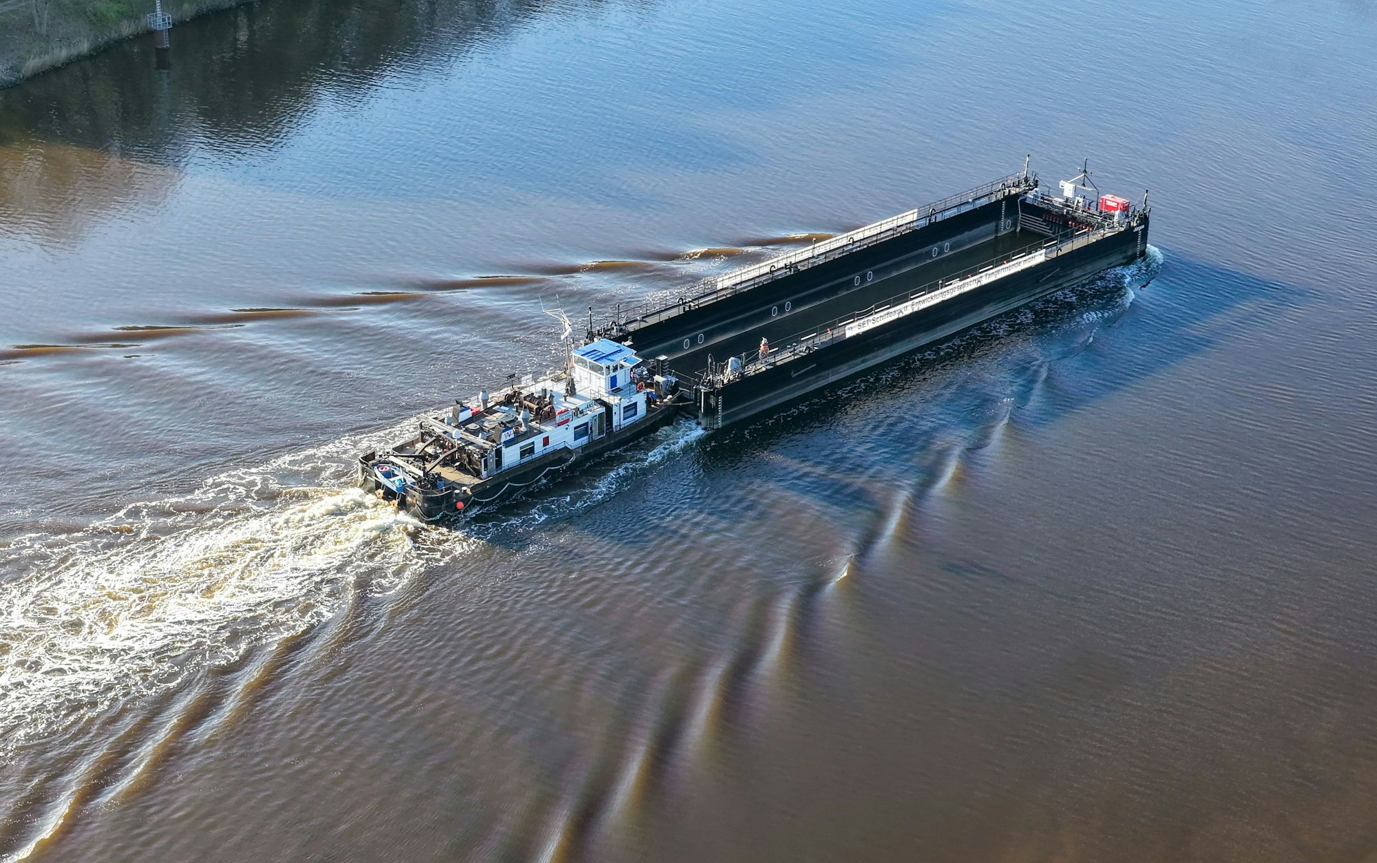 Ein Lastkahn, geschoben von dem Schubschiff „Hans“ fährt auf dem Nord-Ostsee-Kanal bei Hohenhörn.
