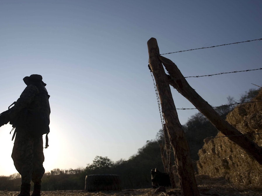 Soldat mit Gewehr und Stacheldrahtzaun