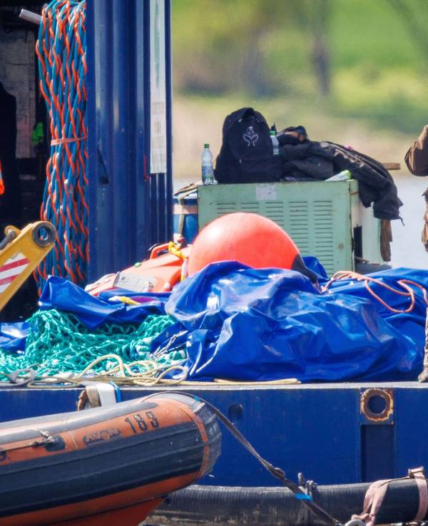 Till Backhaus (r, SPD), Umweltminister von Mecklenburg-Vorpommern, telefoniert, nachdem der gestrandete Buckelwal vor der Insel Poel mit Gurten in den Lastkahn gezogen wurde.