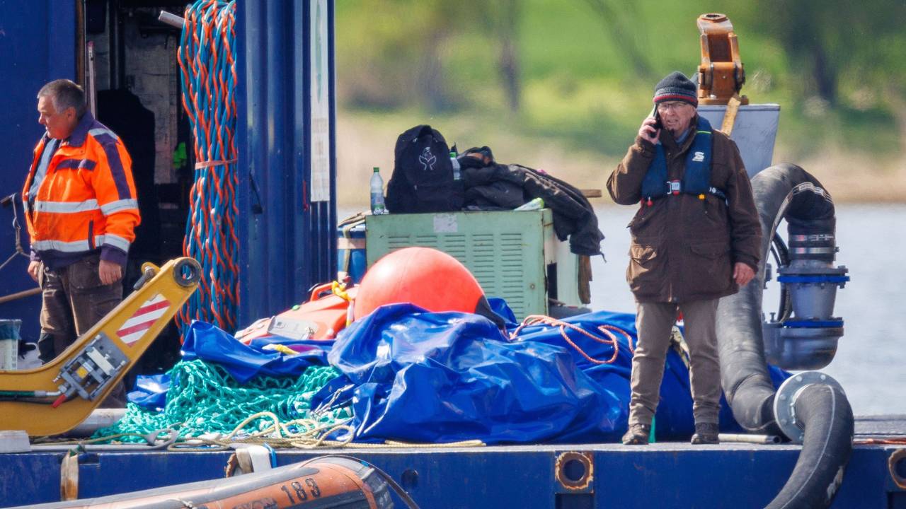 Till Backhaus (r, SPD), Umweltminister von Mecklenburg-Vorpommern, telefoniert, nachdem der gestrandete Buckelwal vor der Insel Poel mit Gurten in den Lastkahn gezogen wurde.